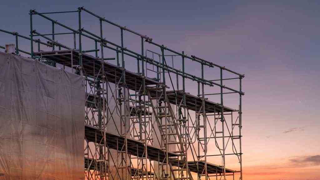Construction,Site,With,Scaffold,Tower,And,Building,With,Sunset,Background,scaffolding